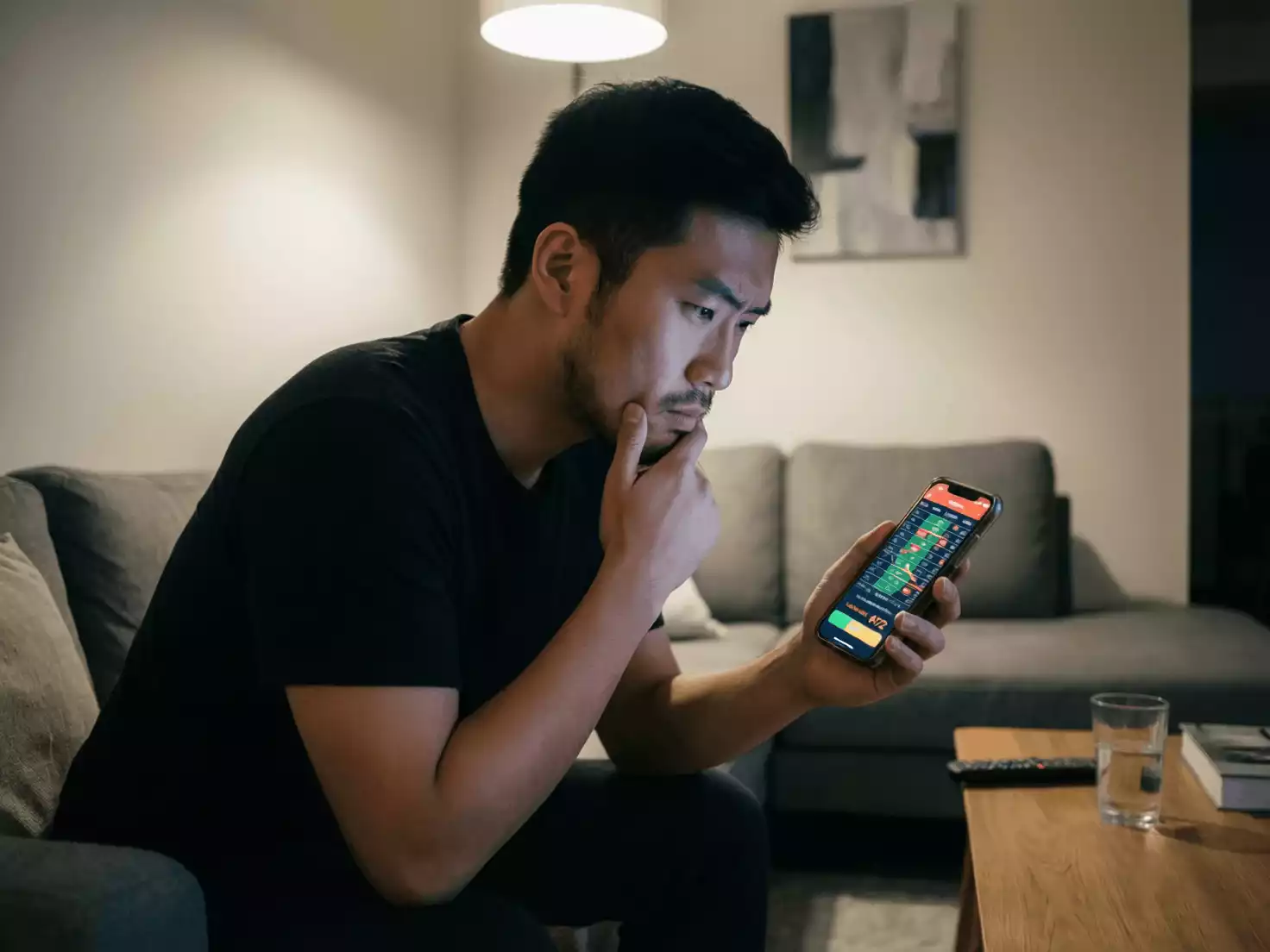 Persona pensativa mirando su móvil decidiendo sobre una apuesta