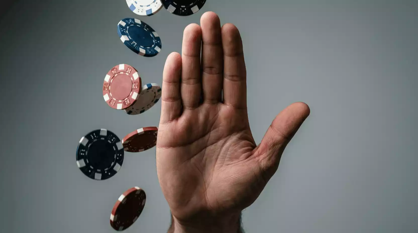 Mano deteniendo fichas de casino simbolizando el control sobre el juego
